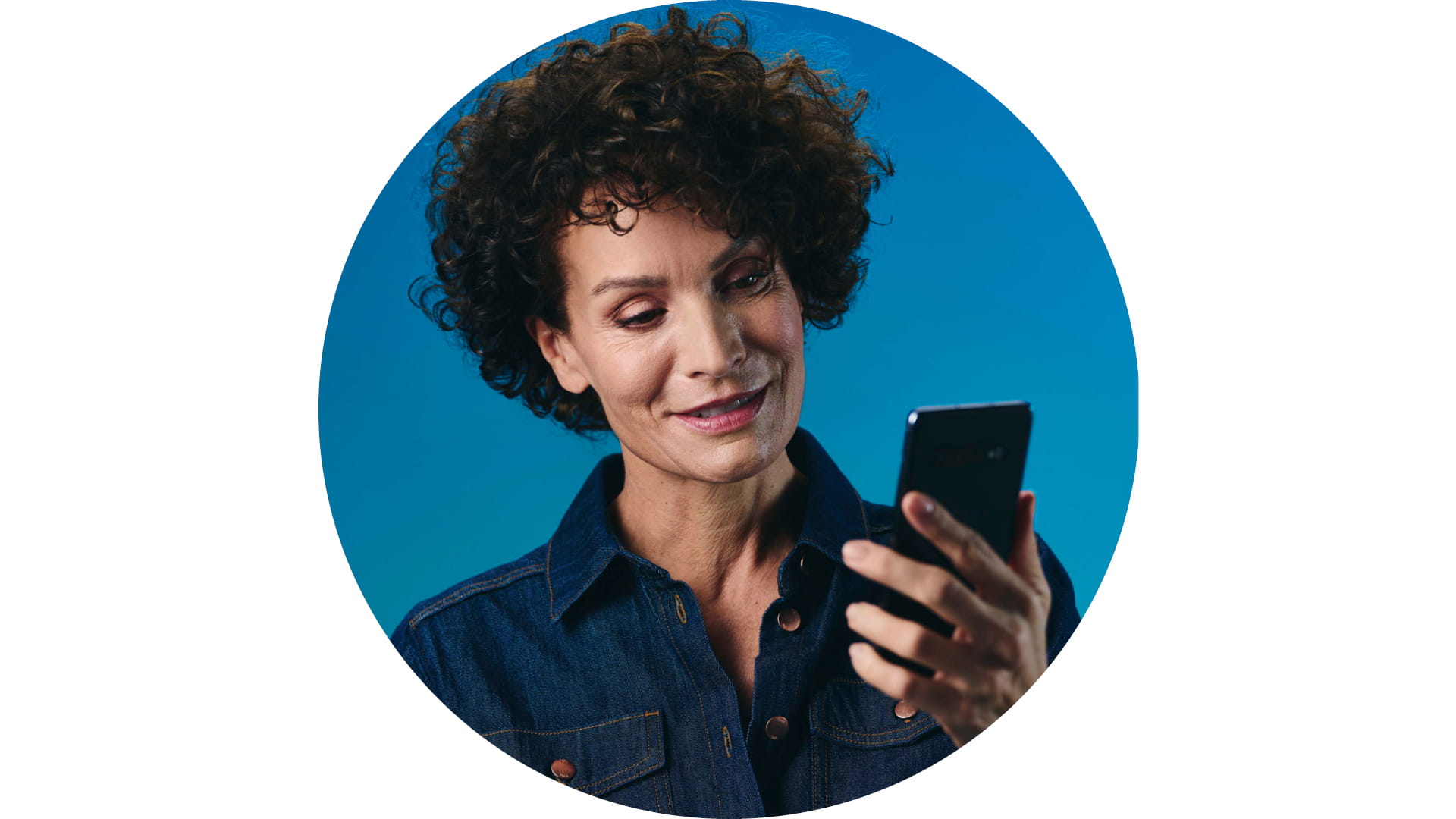 Woman wearing Pure Charge&Go BCT IX hearing aid and looking at smartphone